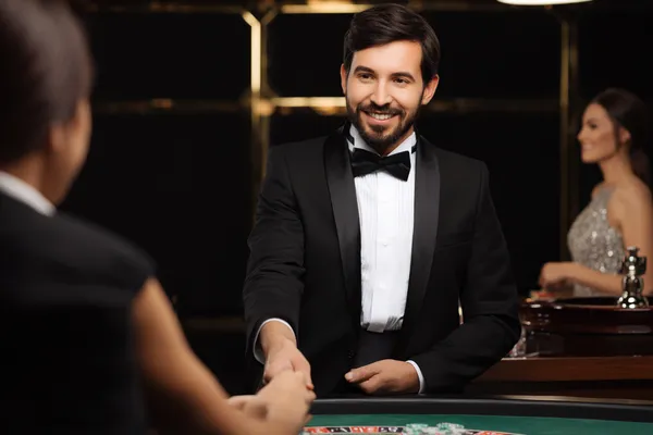 A woman in a luxurious green gown next to an ornate roulette wheel, capturing the upscale casino mood of 456BD.
