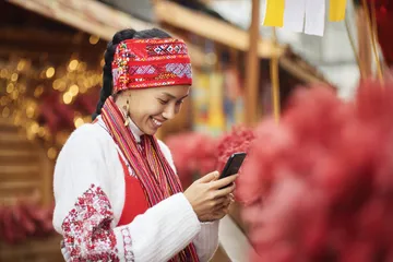A woman smiling by bright slot machines showing lucky symbols, showcasing the exciting slot offerings at 456BD.
